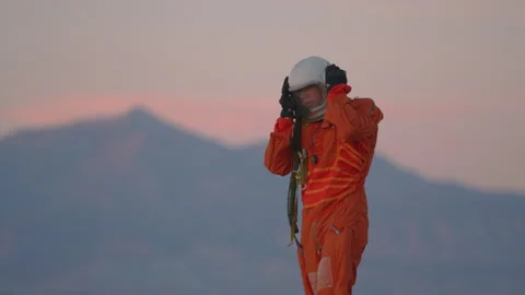 Exploring the desert landscape in astronaut-style attire during sunset hours Stock Footage 288841433