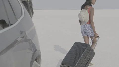 Exploring the desert with a walking car and a suitcase adventure Stock Footage 312647090