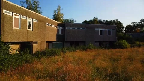 Exploring a deserted building in a field during sunset Stock Footage 339783053