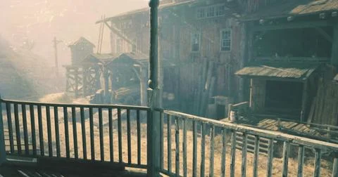 Exploring a dusty old town with rustic buildings under a glowing sky Ilustración de archivo
