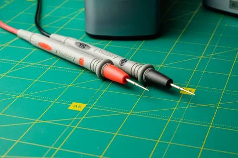 Exploring electrical measurements with test leads on a green workspace Stock Photos