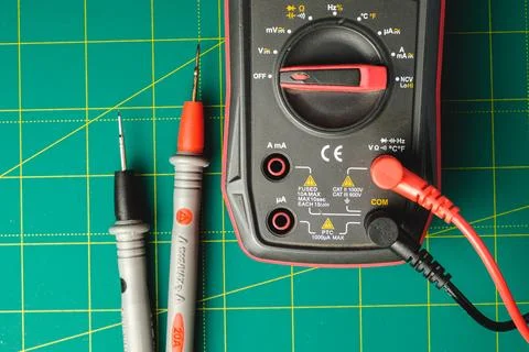 Exploring electronics with a digital multimeter on a vibrant workbench Stock Photos