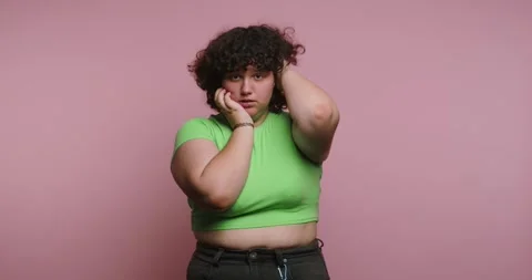Exploring emotions through body language in a studio with pink background a.. 스톡 동영상 331990735