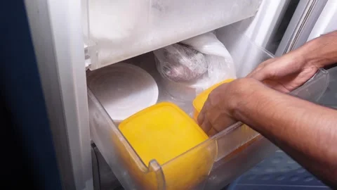 Exploring a freezer full of food items in a kitchen Stock Footage 341646622