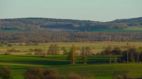 Exploring green fields and hills in rural landscape during late afternoon Vidéo 337525083