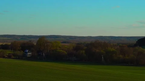 Exploring green fields and trees in a rural area with clear skies and mountains Vidéo 338431145
