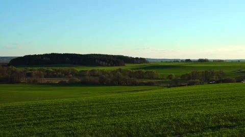 Exploring a green landscape in spring time with trees and hills in the distance Stock Footage 337525072