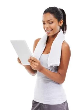 Exploring her new tablets functions. A young woman in gym clothes working on a Foto stock