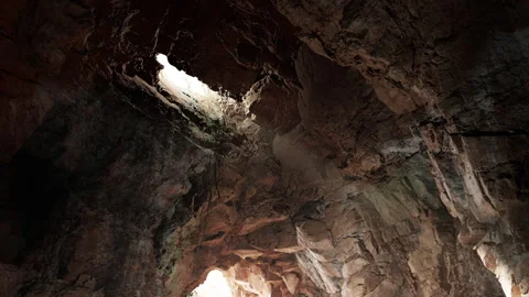 Exploring the Hidden Beauty of a Rocky Cave With Sunlight Streaming In Stock Footage 344824327