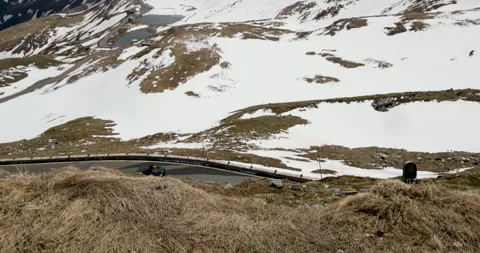 Exploring a high mountain road surrounded by winter snow and grass in the Stock-Footage 314082388