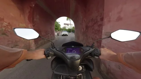 Exploring a historic archway while riding a scooter in a tropical location Stock Footage 308024995