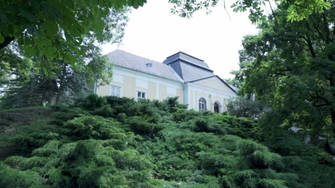 Exploring a historic mansion surrounded by lush greenery in early summer Video stock 291690251