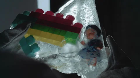 Exploring icy enclosed figurine in abandoned building. Researcher observes Stock Footage 346475962