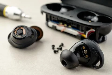 Exploring the inner workings of wireless earbuds during a repair session 库存照片
