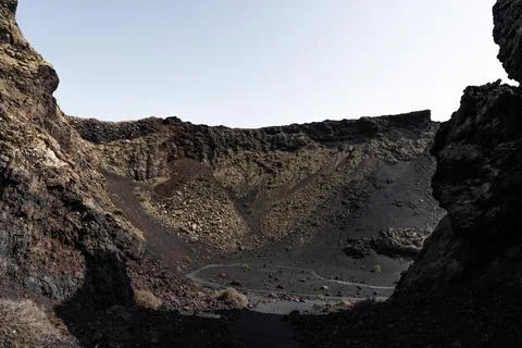 Exploring inside area volcanic crater El Cuervo with rugged rock formations Stock Photos