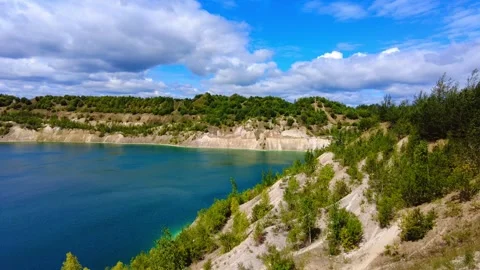 Exploring a lake surrounded by hills and trees on a clear day Video stock 340448150