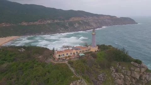 Exploring a lighthouse by the rugged coast during a cloudy day Stock Footage 310851324