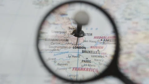 Exploring London on a real paper map with a magnifying glass Stock Footage 340078850