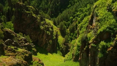 Exploring the lush green valleys and rugged cliffs of a remote mountain Stockbeeldmateriaal 313108865