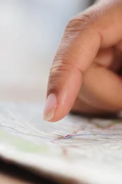 Exploring a map with a finger at a table 库存照片