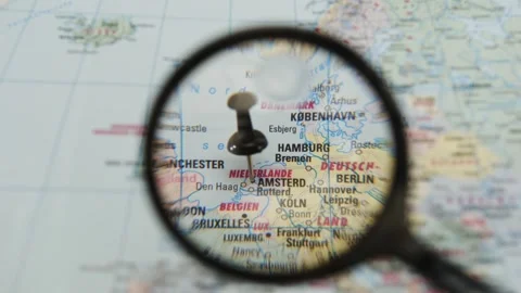 Exploring a map with a magnifying glass over Hamburg Stock Footage 342435976