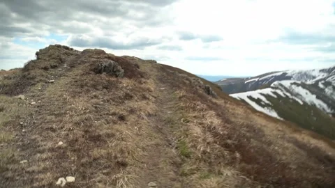 Exploring a mountain trail on a cloudy day in the countryside. Spring Hiking Stock Footage 327139276