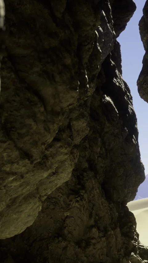 Exploring a narrow rock passage with bright sunlight at the end of the path Stock Footage 332225663