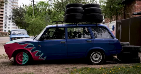 Exploring an Old Painted Car: Nostalgic Vibes, Quirky Roof Tire Collection Stock Footage 243197939
