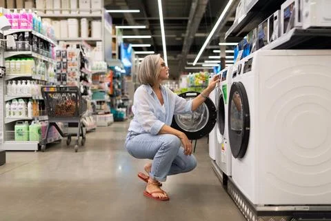 Exploring options in a home appliances store while considering a new washing Stock Photos