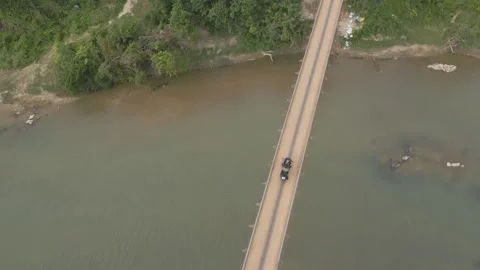 Exploring a quiet bridge over a serene river at sunset Stock Footage 310278564