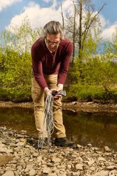 Exploring of river with magnet on rope and finding of axe Stock Photos