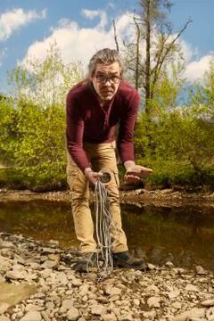 Exploring of river with magnet on rope and finding of axe Stock Photos