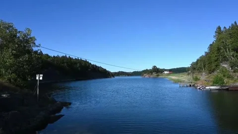 Exploring a river surrounded by trees and a clear blue sky in a calm area o.. Stock Footage 340204699
