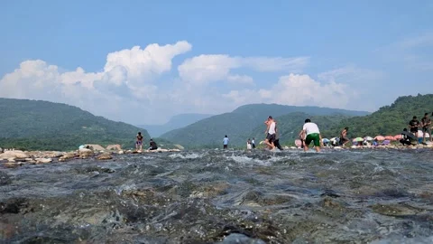 Exploring a river's edge with visitors enjoying recreational activities ami.. Video stock 291434900