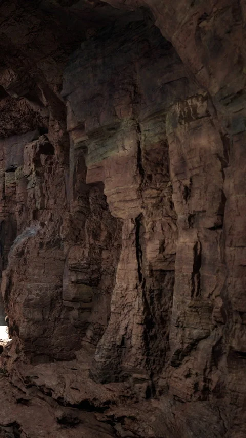 Exploring rock formations in a dark cave with sunlight filtering through Stock Footage 339508127