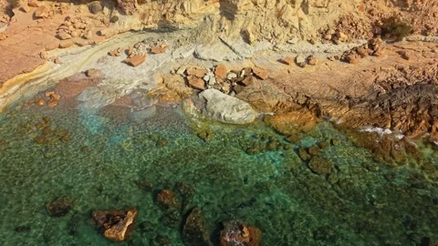 Exploring a rocky beach with clear water and scenic views in the morning sun Stock Footage 340192064