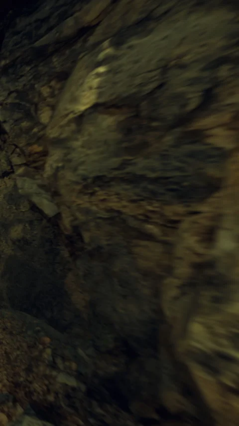 Exploring a rocky cave in the dark with uneven surfaces and formations Stock Footage 339946723