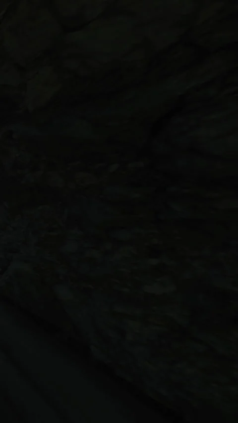Exploring a rocky cave with dim light during an outdoor adventure Stock Footage 339952711