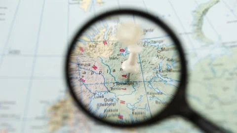 Exploring Rovaniemi a destination on a paper map with a magnifying glass Stock Footage 340079019