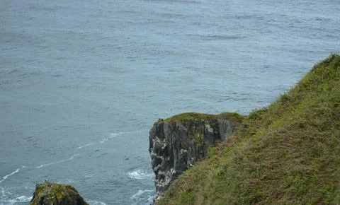 Exploring Rugged Cliffs by the Sea at Sunset With Adventurous Spirits Stock Photos