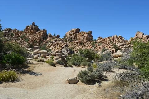 Exploring Rugged Rock Formations Under a Clear Blue Sky at Midday Foto stock