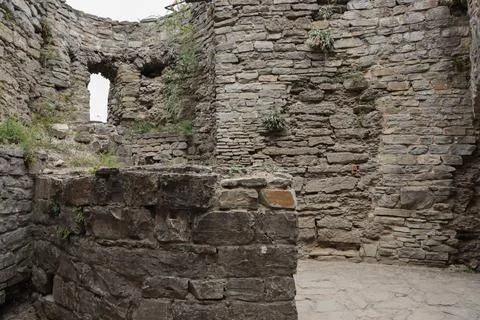 Exploring the ruins of an old stone structure in a remote area surrounded by Photos
