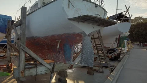 Exploring a rustic boat yard nestled at the water's edge in a sheltered bay Stock-Footage 107599167