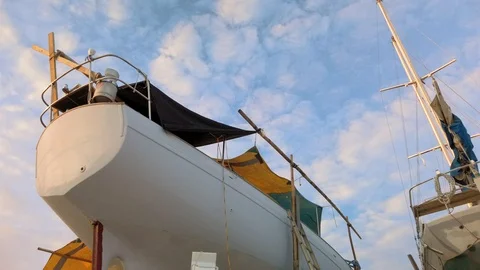 Exploring a rustic boat yard nestled at the water's edge of a sheltered bay Stock-Footage 107647340