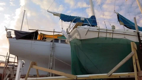 Exploring a rustic boat yard nestled at the water's edge of a sheltered bay Video stock 107649834