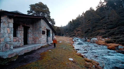 Exploring a rustic stone cabin near a flowing river in the Pyrenees Stock Footage 303628354