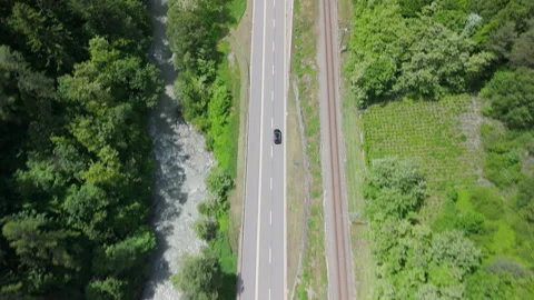 Exploring the scenic highway alongside lush greenery and tranquil waters in the Stockbeeldmateriaal 314080673