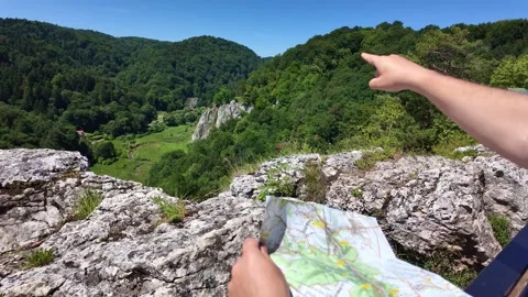 Exploring scenic mountain landscape with map and pointing gesture Stock Footage 331580588