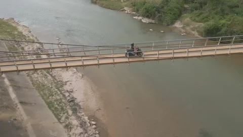 Exploring a scenic river and pedestrian bridge in a peaceful natural setting Stock Footage 310278715