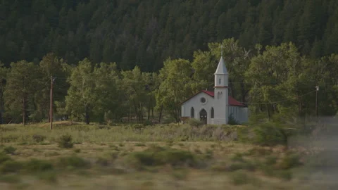 Exploring serene forest pathways with cars near a charming church Stock Footage 288574267
